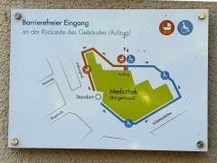 Auf einem Schild vor der Mediathek ist erklärt, wo der barrierefreie Eingang ist.