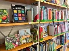 In einem Regal stehen verschiedene Koch- und Hobbybücher.