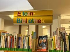 Über einem Bücherregal hängt das Schild "Elternbibliothek".