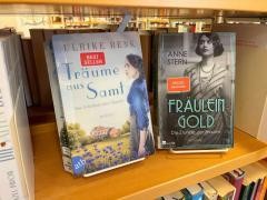 In einem Regal stehen zwei Bücher mit dem Spiegel-Bestseller-Logo.