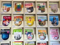 Verschiedene Zeitschriften liegen in einem Regal.