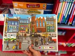 Eine Person hält ein geöffnetes Buch für Kinder in der Hand.