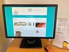 Eine Person bedient den Recherche-PC in der Mediathek.