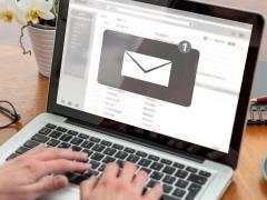 Auf einem Laptop-Bildschirm ist ein E-Mail-Postfach geöffnet. Auf dem Bildschirm erscheint eine große E-Mail-Benachrichtigung.