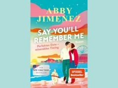 Vor einem blauen Hintergrund steht das Buchcover von "Say you'll remember me."