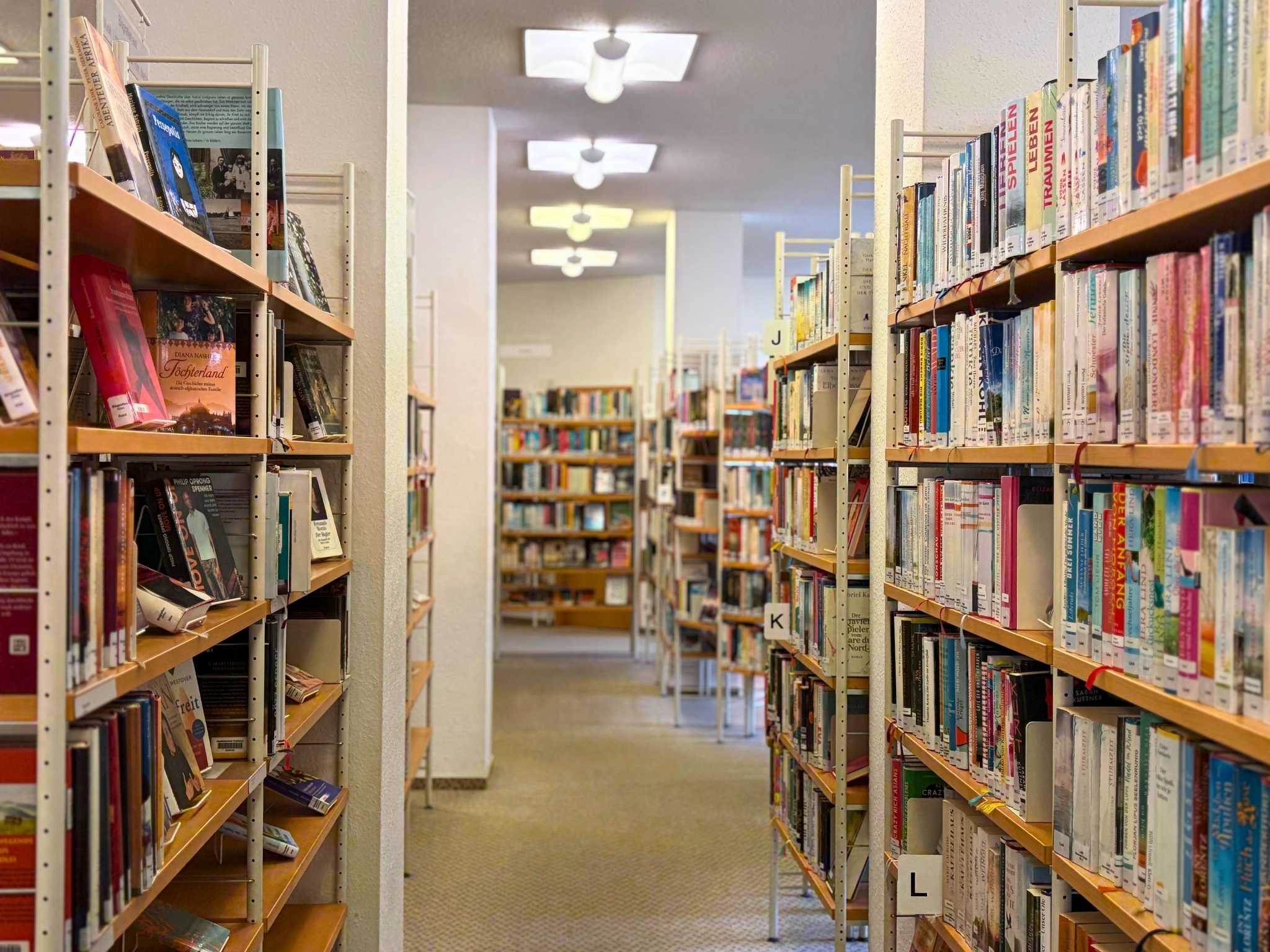 Innenansicht der Waldkircher Mediathek. Rechts und links eines Ganges sind B&uuml;cherregale.