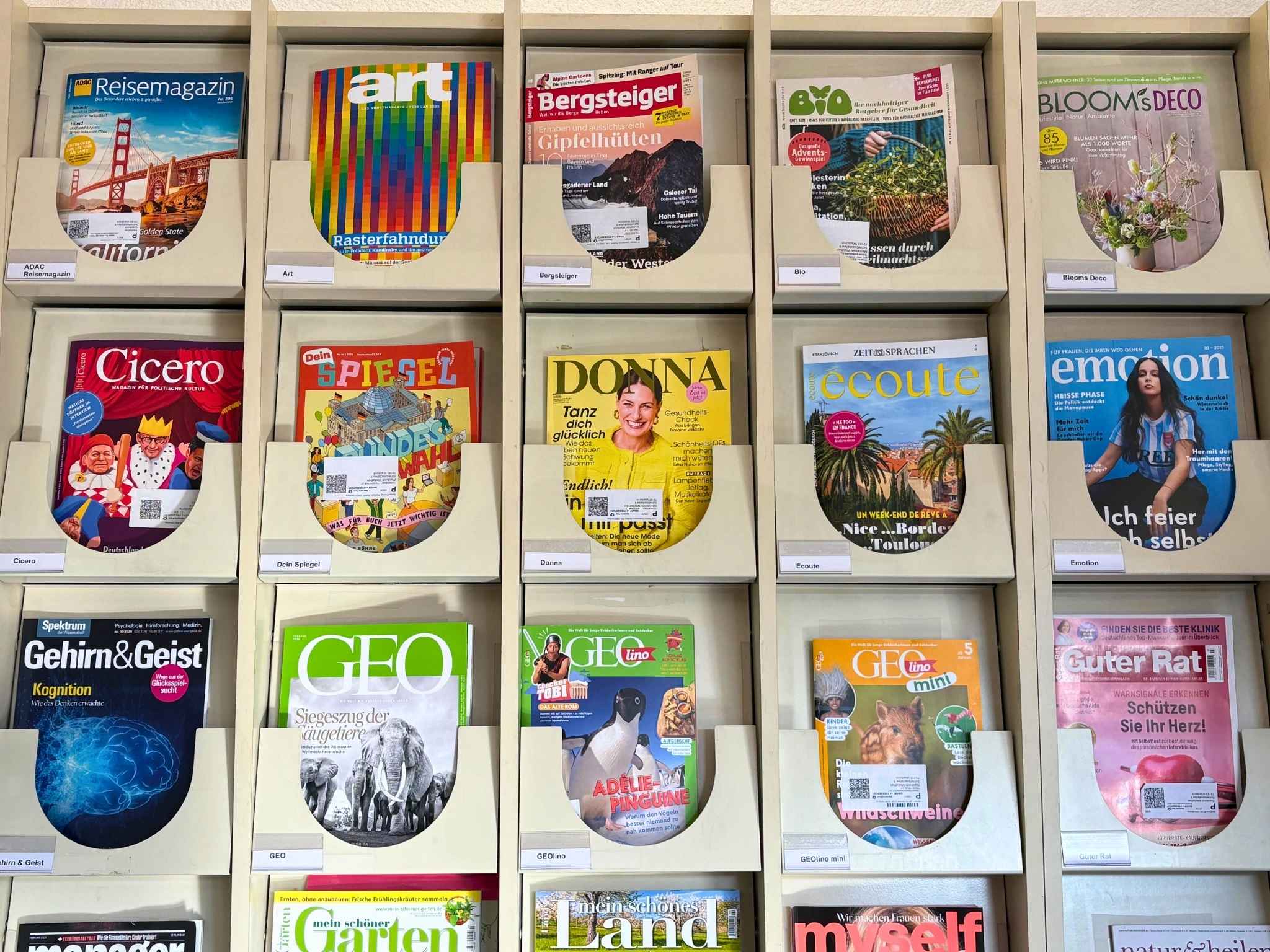 Verschiedene Zeitschriften liegen in einem Regal.